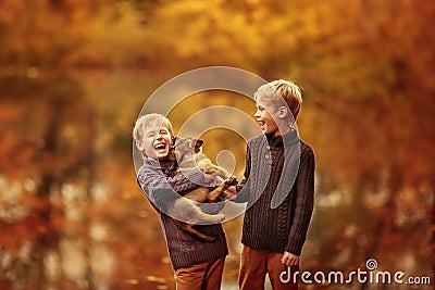 Two boys playing with a dog Stock Photo