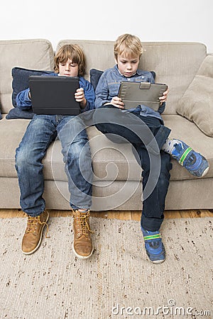 Two boys playing video games on a tablet computer Stock Photo