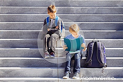 Two boys reading, doing homework outdoors. Back to school concept. Stock Photo