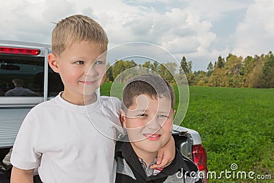 Two boys siiting on a car trunk Stock Photo