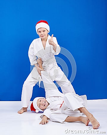 Two boys are trained judo throws in Santa Claus caps Stock Photo