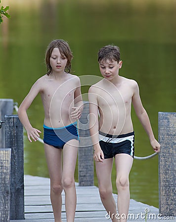 Two Boys Walking on Jetty Stock Photo