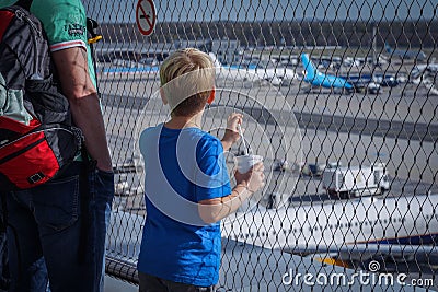 the two boys watch planes from the airport roof over their heads Editorial Stock Photo