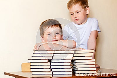 Two boys in white t-shirts at the table with books. school Stock Photo