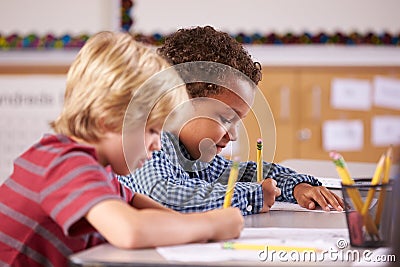 Two boys working at their desks in elementary school class Stock Photo