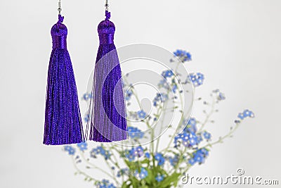 Two bright purple earrings-brush and blue bouquet of forget-me-nots Stock Photo