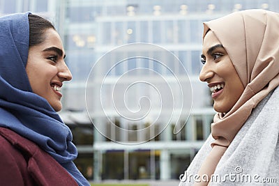 Two British Muslim Women Friends Meeting Outside Office Stock Photo