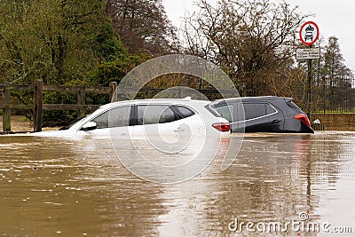 Two Broken Down Cars Submerged In a flooded Ford / River. UK Editorial Stock Photo