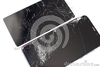 Two broken phones of white and black on a white background. cracked touchscreen glass of the touch screen isolate Stock Photo