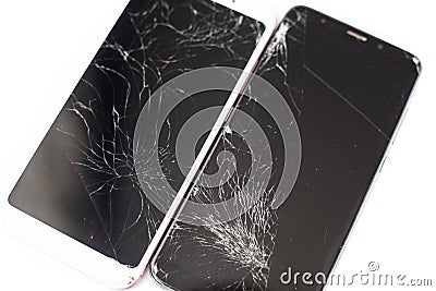 Two broken phones of white and black on a white background. cracked touchscreen glass of the touch screen isolate Stock Photo