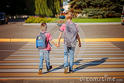Two brothers with backpack walking, holding on warm day on the Stock Photo