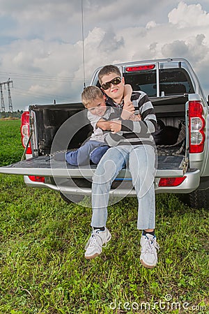 Two brothers siiting on a car trunk Stock Photo