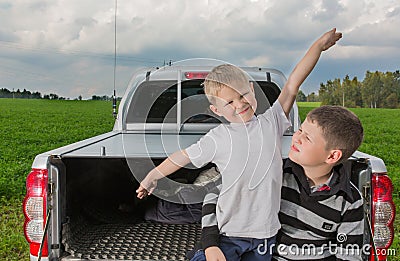 Two brothers siiting on a car trunk Stock Photo