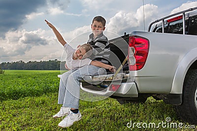 Two brothers siiting on a car trunk Stock Photo