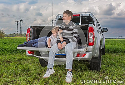 Two brothers siiting on a car trunk Stock Photo