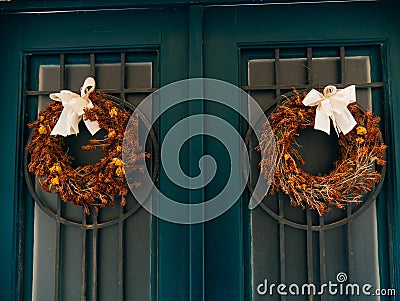 Two brown wreaths with bows on green doors Stock Photo