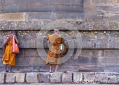 Two Buddhist monks talking to the Dhamekh Stupa. Editorial Stock Photo