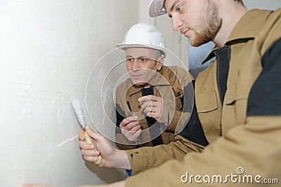 Two builders making finish in apartment Stock Photo