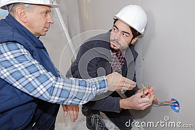 Two builders working with electricity indoors Stock Photo