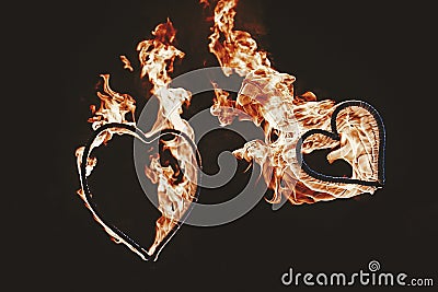 Two burning hearts for wedding couple, amazing fire show at nigh Stock Photo