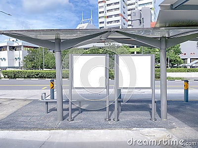 Two bus stop blank advertising mock ups at empty bus stop shelter by main road. Out-of-home OOH classifieds billboard Stock Photo