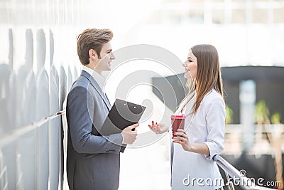 Two Business Colleagues standing in office hall having informal discussion with coffee Stock Photo