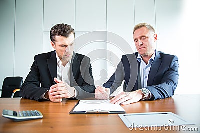 Two business people signing a document Stock Photo