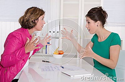 Two business woman disputing in the office having disagreement. Stock Photo