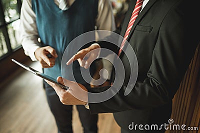 Two businessman looking and point finger to detail in notebook, they are meeting and talking about business plan, Stock Photo