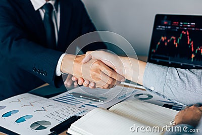 Two businessmen agreed to buy and sell shares by shaking hands in order to accept mutual investment Stock Photo