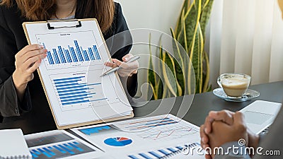 Two businessmen analyzed cost graphs on desks in conference rooms with graphs and coffee mugs Stock Photo