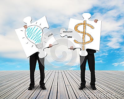 Two businessmen assembling puzzles for Idea is Money doodles Stock Photo