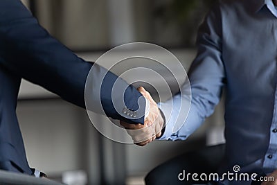 Two businessmen in formal suits shaking hands after successful negotiations Stock Photo