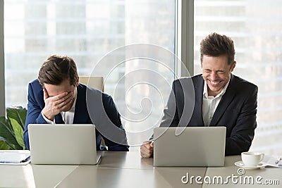 Two businessmen laughing out loud, good positive emotions at wor Stock Photo