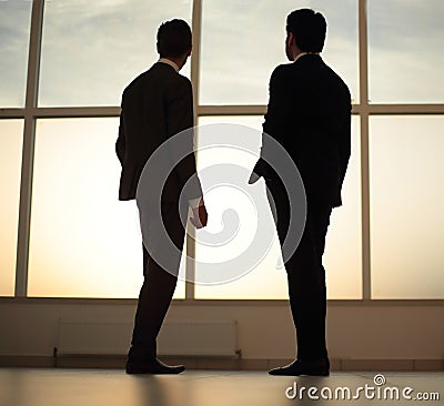 Two businessmen look at the city from the window of the business center Stock Photo