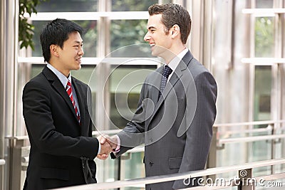 Two Businessmen Shaking Hands Outside Office Stock Photo