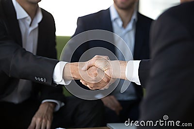 Two businessmen in suits shake hands at meeting, close up Stock Photo