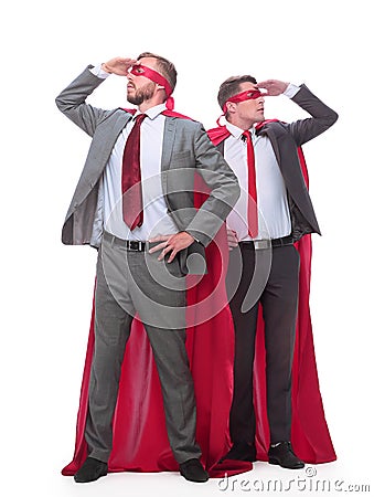 Two businessmen in superhero raincoats looking in different directions. Stock Photo