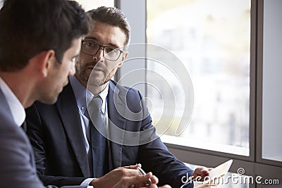 Two Businessmen Using Digital Tablet In Office Meeting Stock Photo