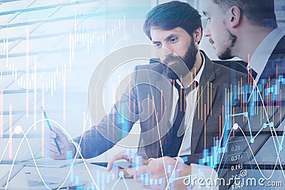 Two businessmen wearing suits analyze stock market at the workpl Stock Photo