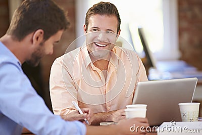 Two Businessmen Working At Desk Together Stock Photo
