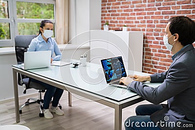 Two Businesspeople Analyzing Financial Graph On Laptop Stock Photo
