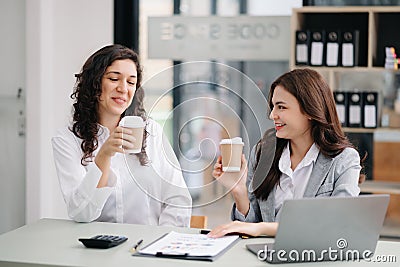 Two businesswoman discuss investment project working and planning strategy with tablet laptop computer in office Stock Photo