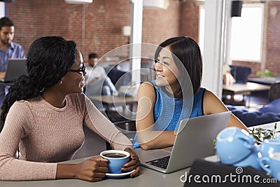 Two Businesswomen Have Informal Meeting In Office Coffee Bar Stock Photo