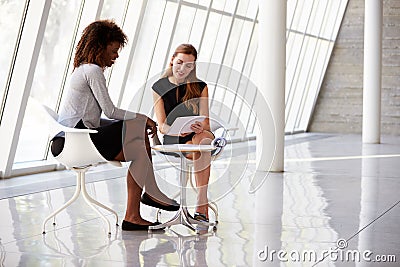 Two Businesswomen Meeting In Reception Of Modern Office Stock Photo