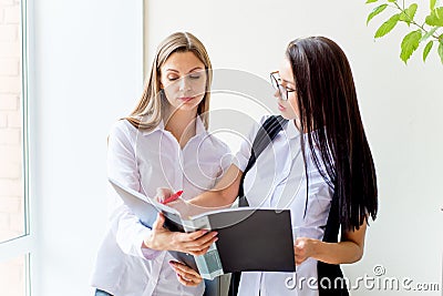 Two businesswomen telling gossip in an office Stock Photo