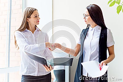 Two businesswomen telling gossip in an office Stock Photo