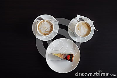 Two cappuccinos and a piece cheesecake Stock Photo