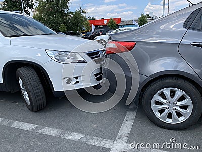 Two cars next to each other. Cars are parked very close. Small clearance from bumper to bumper Editorial Stock Photo