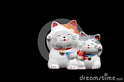 two ceramic lucky cats for decoration isolated on black Stock Photo